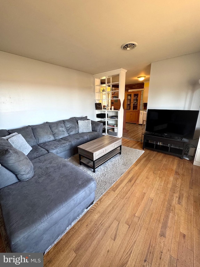 living area featuring visible vents and hardwood / wood-style flooring