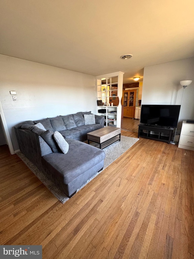 living room featuring visible vents and hardwood / wood-style floors