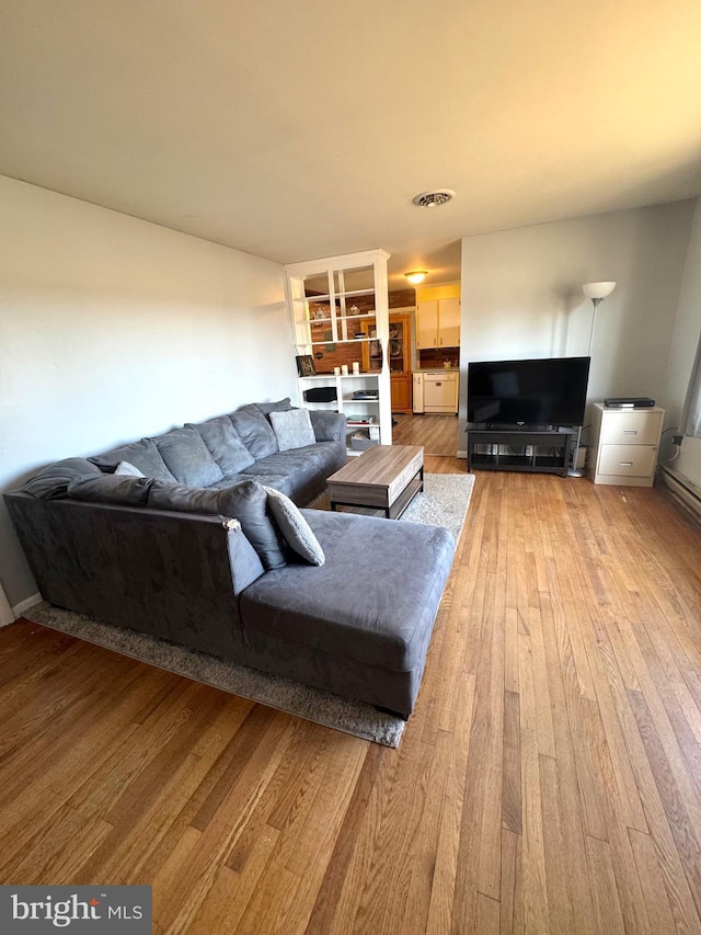 living area with light wood-type flooring and visible vents