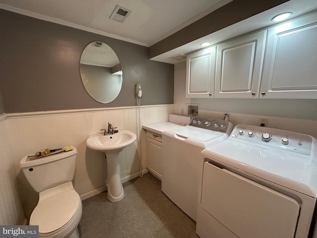 laundry room with washing machine and dryer, a wainscoted wall, laundry area, visible vents, and crown molding