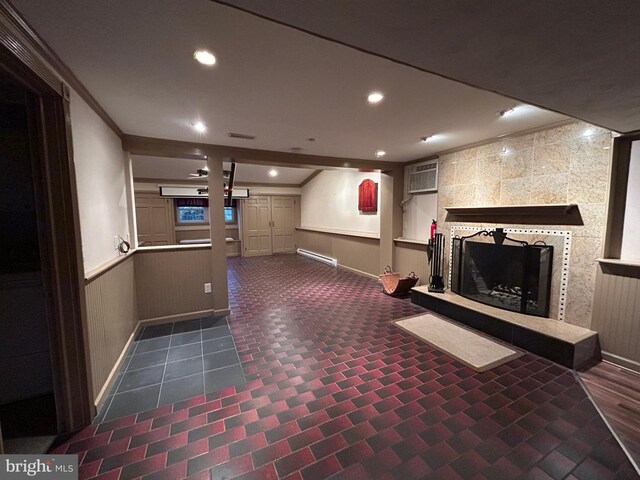 interior space with a tile fireplace, a wainscoted wall, baseboard heating, crown molding, and recessed lighting