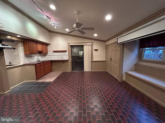 kitchen featuring crown molding, recessed lighting, brown cabinetry, vaulted ceiling, and a sink