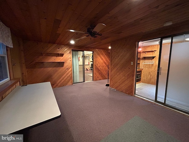 interior space featuring wooden ceiling, wood walls, and ceiling fan