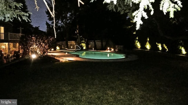 pool at night featuring an outdoor pool