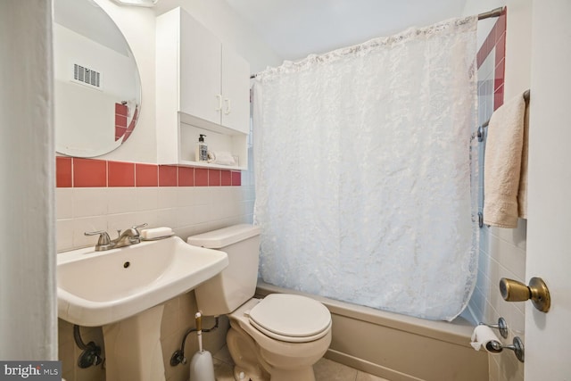 full bathroom with visible vents, decorative backsplash, shower / bath combo with shower curtain, tile walls, and toilet