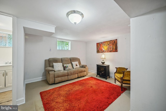 living room with a wood stove and baseboards