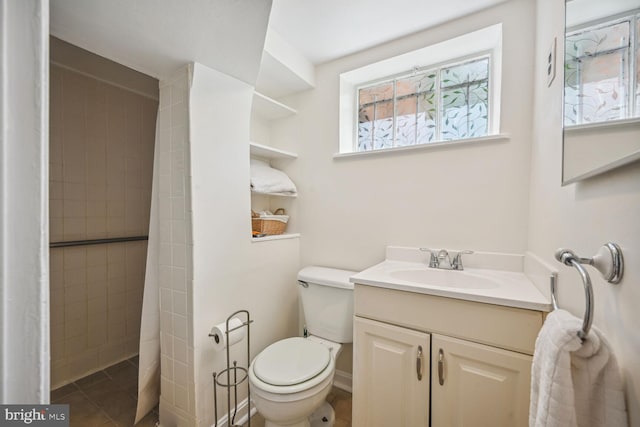 bathroom with vanity, toilet, and tiled shower