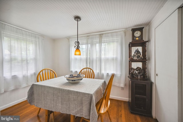 dining space featuring baseboards and wood finished floors