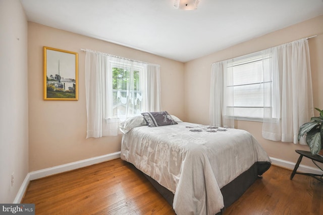 bedroom with baseboards and wood finished floors