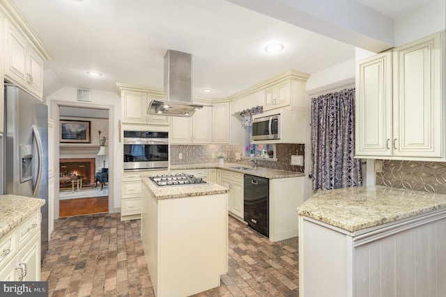 kitchen featuring island exhaust hood, stainless steel appliances, cream cabinets, and decorative backsplash