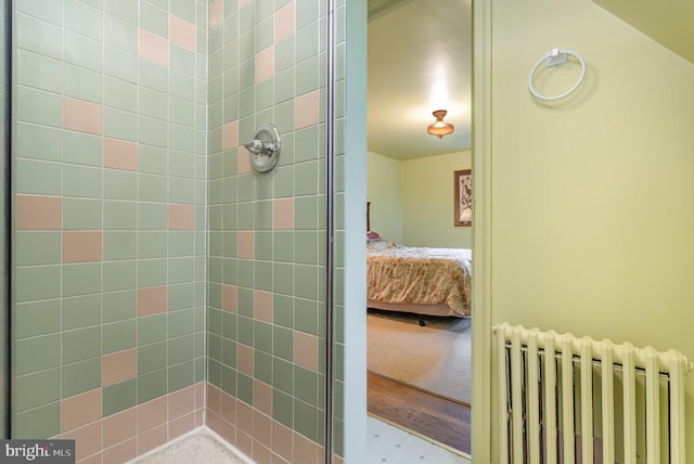 full bathroom with a shower stall, connected bathroom, and radiator heating unit