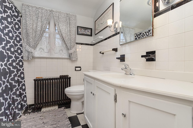 full bathroom featuring vanity, toilet, tile walls, and radiator heating unit