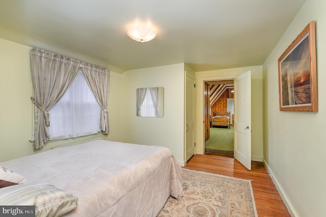 bedroom featuring baseboards and wood finished floors