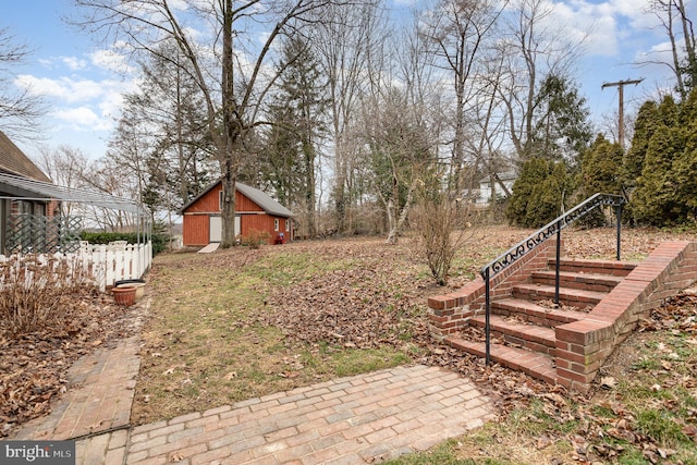 view of yard featuring a storage unit, an outdoor structure, and stairway