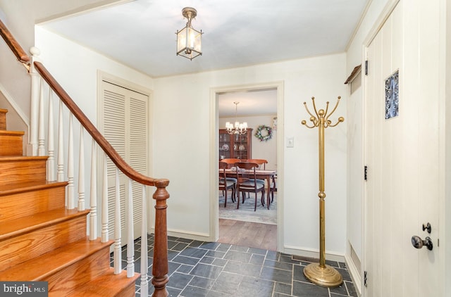 entrance foyer featuring an inviting chandelier, stairway, and baseboards