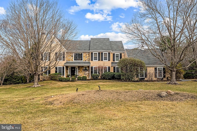 view of front of home featuring stone siding and a front yard