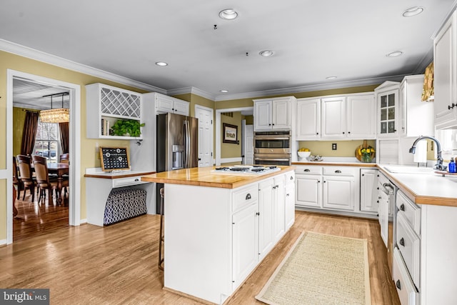 kitchen featuring white cabinetry, a center island, stainless steel appliances, and a sink