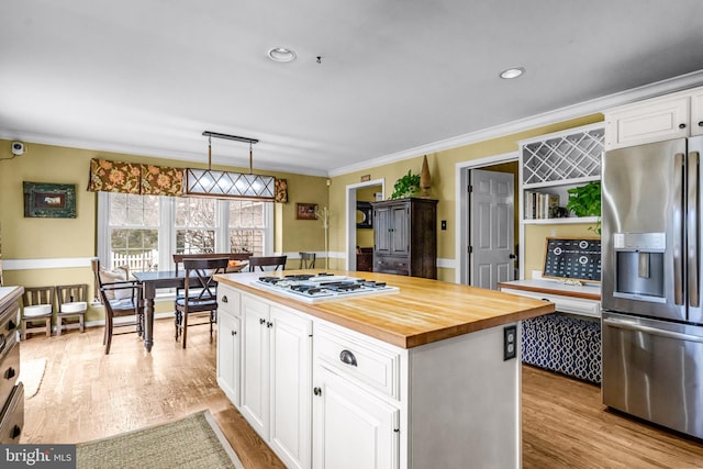 kitchen featuring light wood finished floors, wood counters, white gas stovetop, and stainless steel fridge with ice dispenser