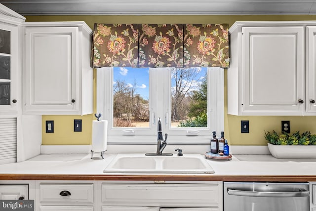 kitchen featuring a sink, dishwasher, white cabinets, and light countertops