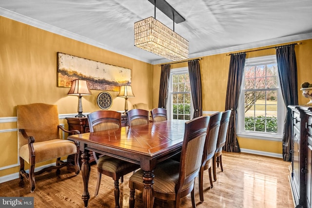 dining room with baseboards, light wood-style floors, and ornamental molding