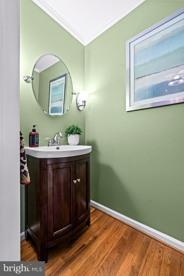 bathroom featuring wood finished floors, baseboards, and ornamental molding