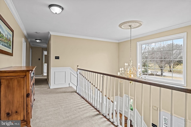 hall featuring an upstairs landing, ornamental molding, and carpet flooring