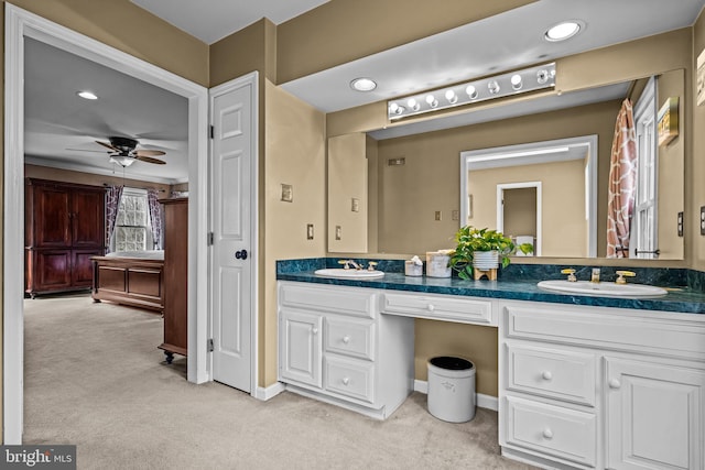 bathroom featuring double vanity, carpet flooring, a ceiling fan, and a sink