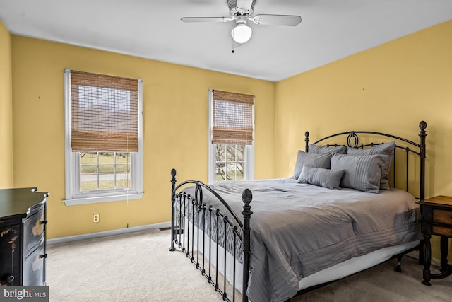 bedroom with carpet flooring, multiple windows, a ceiling fan, and baseboards