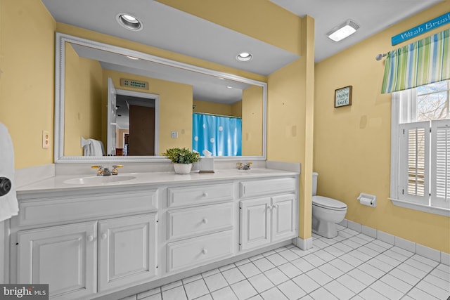 bathroom with a sink, toilet, and tile patterned flooring