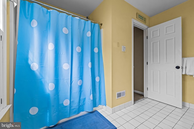 bathroom featuring visible vents, baseboards, curtained shower, and tile patterned flooring