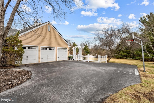 view of side of property featuring a garage and fence