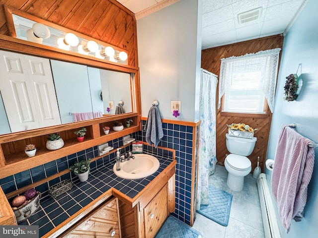 full bathroom featuring vanity, visible vents, a baseboard heating unit, tile patterned floors, and toilet