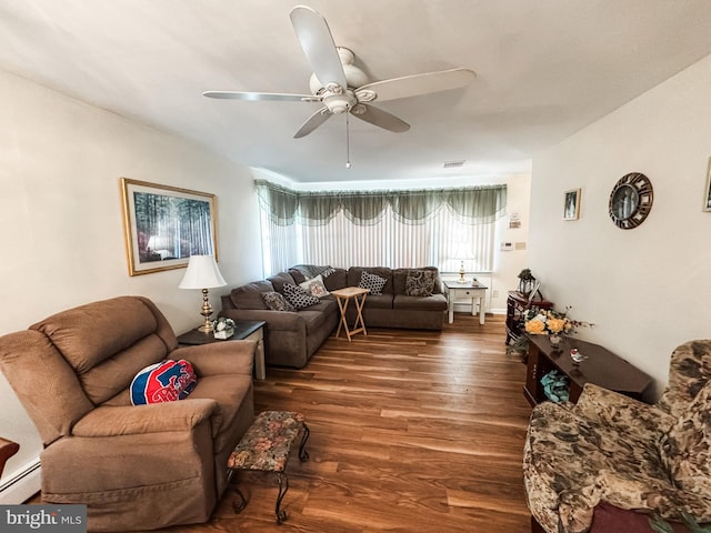 living room featuring dark wood finished floors, visible vents, a baseboard heating unit, and ceiling fan