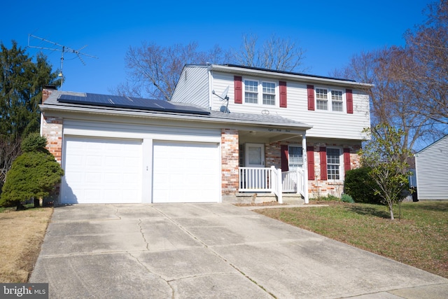 view of front of house with covered porch, brick siding, roof mounted solar panels, and an attached garage