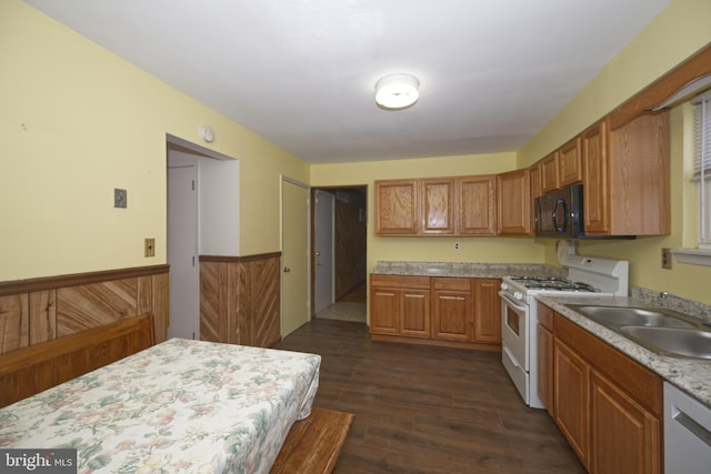 kitchen featuring dishwasher, a wainscoted wall, light countertops, white gas stove, and black microwave