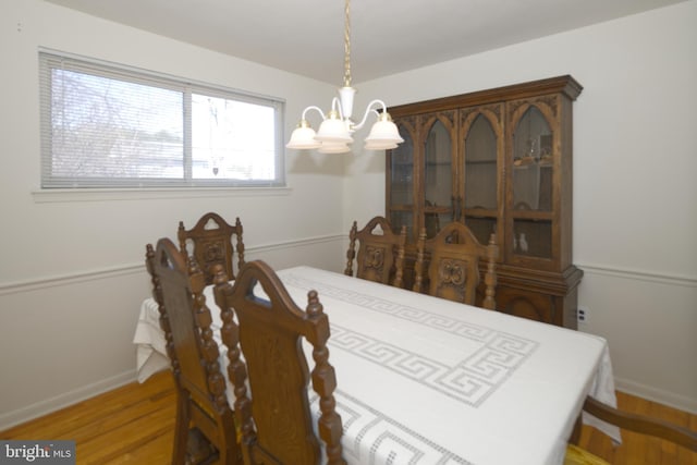 dining room with an inviting chandelier, baseboards, and wood finished floors