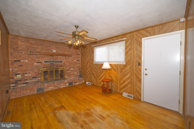 unfurnished living room with visible vents, a fireplace, and hardwood / wood-style floors