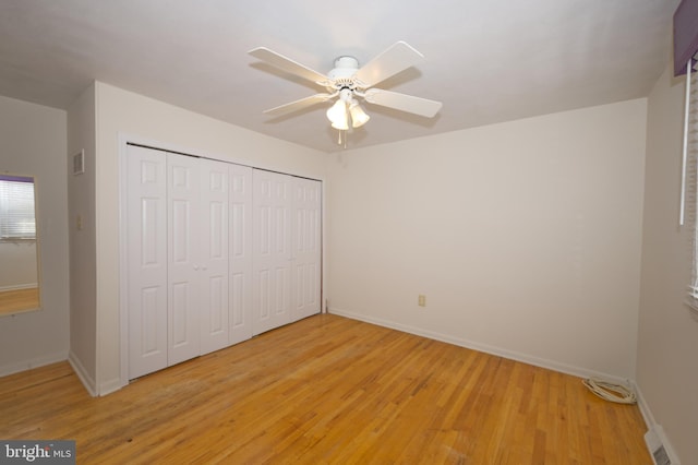 unfurnished bedroom with light wood-type flooring, a closet, visible vents, and baseboards