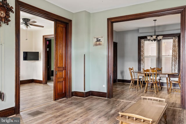 dining area featuring visible vents, baseboards, wood finished floors, and ceiling fan with notable chandelier