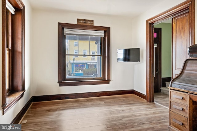 interior space with baseboards and wood finished floors