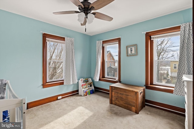 carpeted bedroom featuring baseboards and a ceiling fan