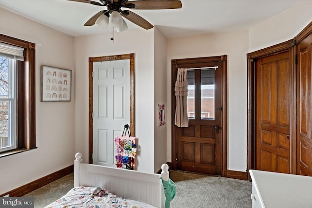 bedroom featuring baseboards, light colored carpet, and ceiling fan