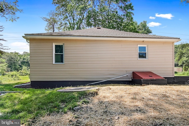 view of side of home featuring a shingled roof