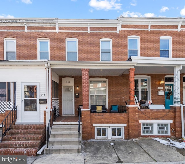 multi unit property featuring brick siding and a porch