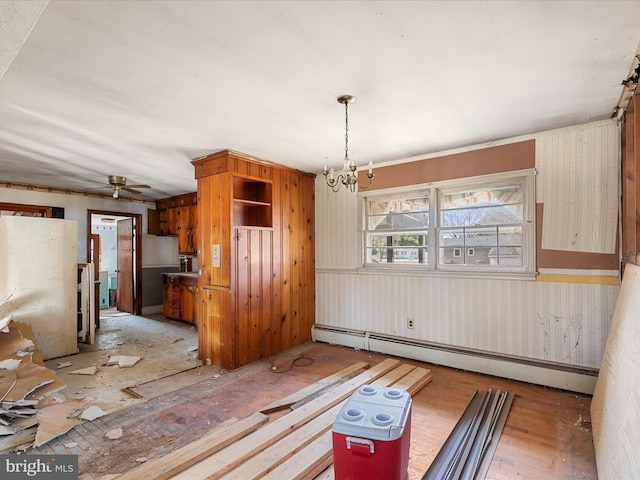 unfurnished dining area with a baseboard heating unit and ceiling fan with notable chandelier