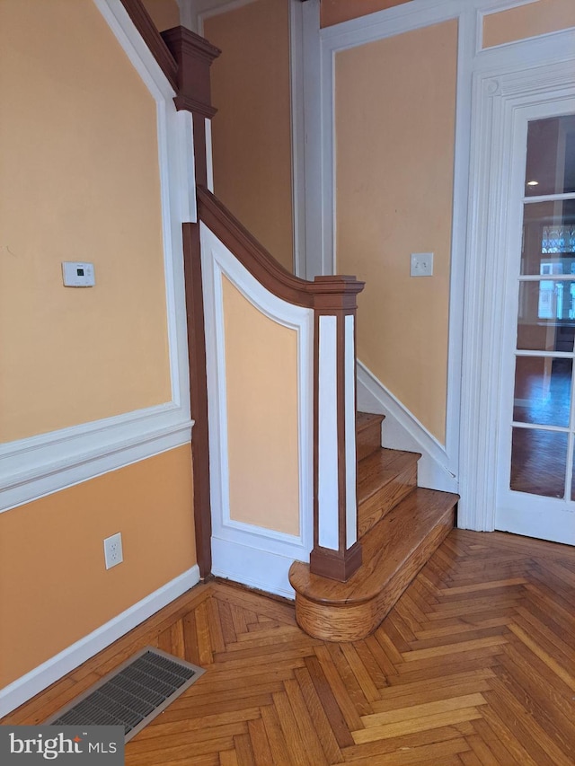 stairs with baseboards and visible vents