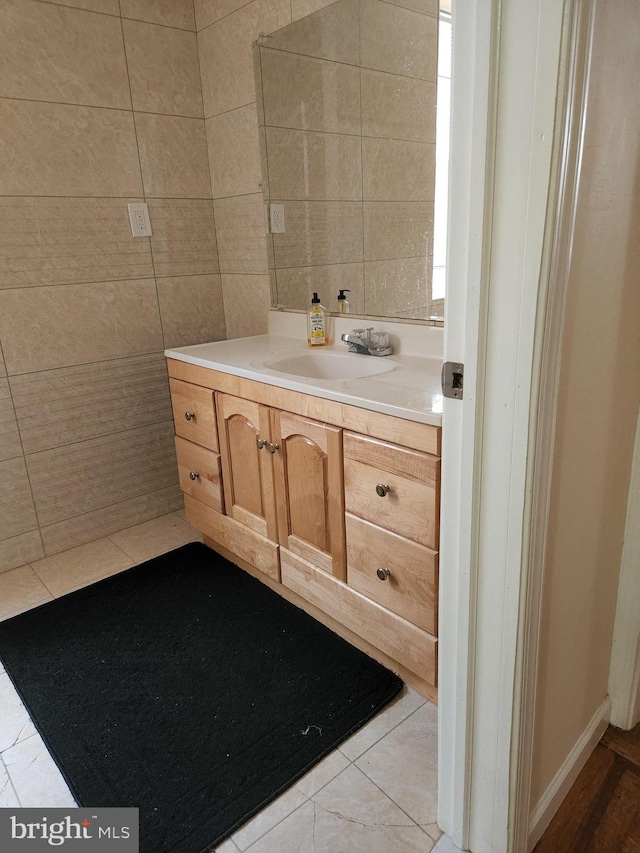 bathroom with tile walls, vanity, and tile patterned floors