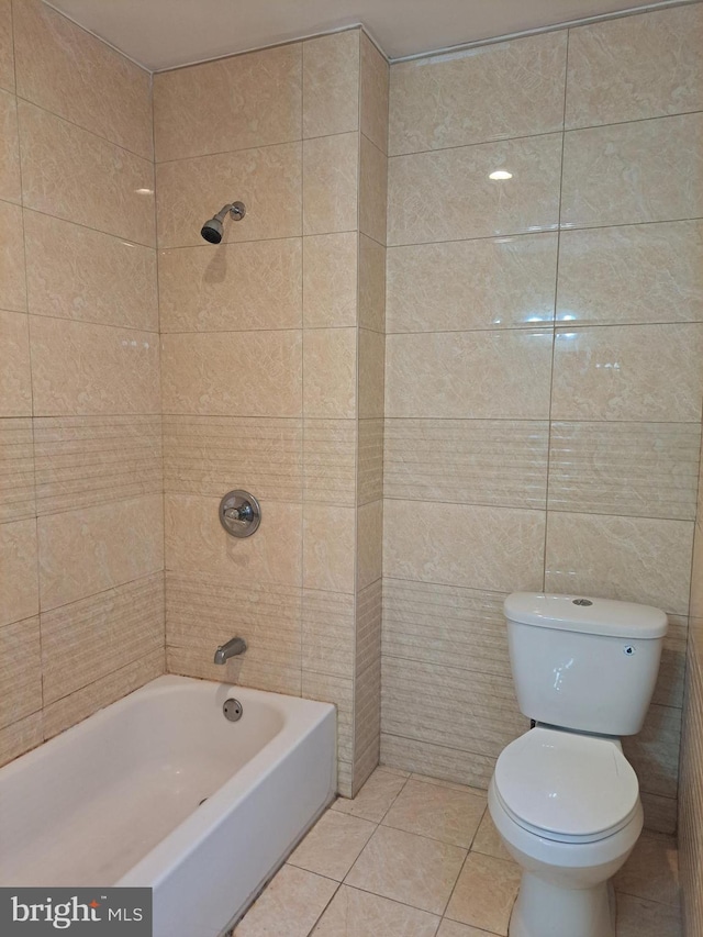 bathroom with tile patterned flooring, tub / shower combination, and toilet