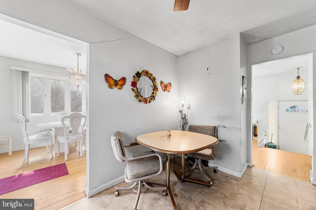 dining room with baseboards and a chandelier