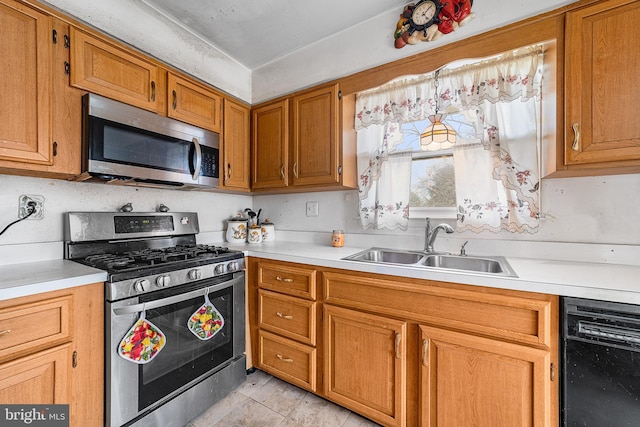 kitchen with appliances with stainless steel finishes, light countertops, and a sink